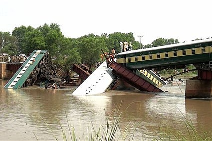 Cars of a passenger train fall after a bridge collapse led a train into a canal in Wazirabad, near Lahore, Pakistan Friday, July 3, 2015. Pakistan's military said Friday the death toll from an accident to a special train that plunged into a canal because