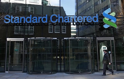 A man walks past the head office of Standard Chartered bank in the City of London | REUTERS