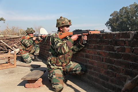 Indian army soldiers take positions on a rooftop of a building outside the Indian airbase in Pathankot, 430 kilometers (267 miles) north of New Delhi, India, Saturday, Jan. 2, 2016. At least four gunmen entered an Indian air force base near the border wit