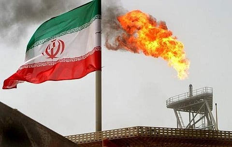 Gas flare on an oil production platform in the Soroush oil fields is seen alongside an Iranian flag in the Gulf. 