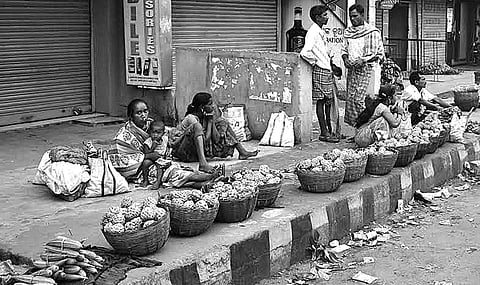 Women selling custard apples wait for customers in Rayagad town on Wednesday. | EPS