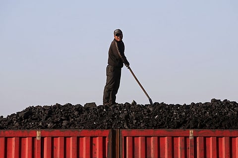 A worker speaks as he loads coal on a truck at a depot near a coal mine. (File photo | Reuters)