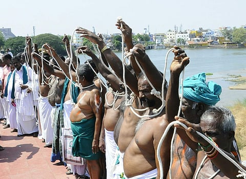 Farmers staging protest over Cauvery bridge near Srirangam on Tuesday seeking constitution of Cauvery Management Board. (M K Ashok Kumar | EPS)