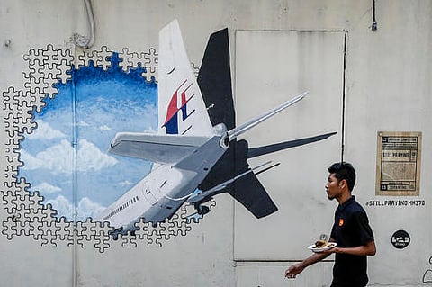 A waiter walks past a mural of flight MH370 in Shah Alam outside Kuala Lumpur, Malaysia. (File Photo |AP)