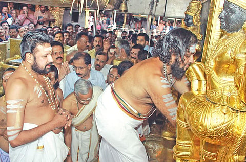 Melsanthi Sankaran Nampoothiri opening the Sreekovil of Sabarimala Lord Ayyappa temple, marking the beginning of the pilgrimage festival season, on Tuesday. Thantri Kandararu Rajivaru also seen | Expr