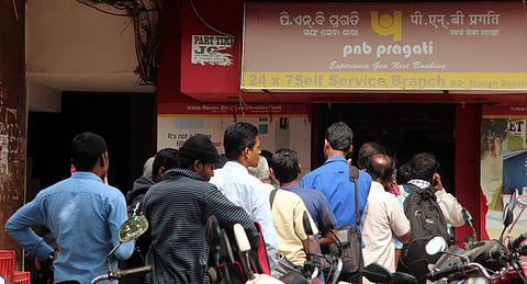 People wait outside an ATM kiosk. (Photo | EPS)