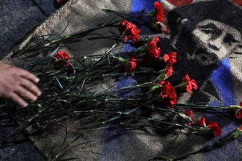 Roses are placed by members of Mexico's communist party atop an image of late Cuban President Fidel Castro | AP