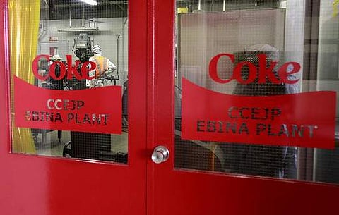 FILE - Coke logo is seen on the door of Coca-Cola Ebina plant in Ebina, Kanagawa Prefecture, near Tokyo | AP