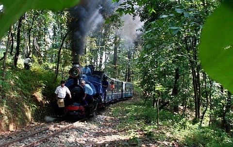 In this file picture, a train of the Darjeeling Himalayan railway (DHR), also known as the Toy Train, moves along the the track on its way to the hill station of Darjeeling.(Photo| AFP)