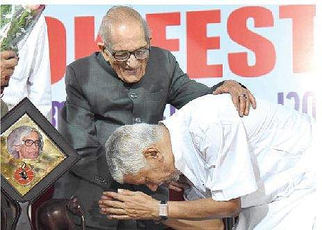 Poet S Ramesan Nair bows before Sanskrit scholar Satya Vrat Shastri after receiving Balamani Amma Award at a function held in Kochi on Friday.