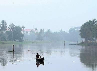 A lone fisherman rows down the Kadambrayar on a misty morning    Express