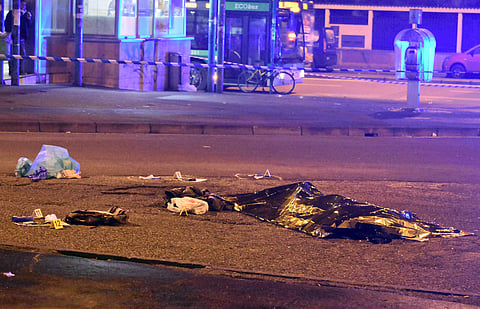 A thermical blanket covers a body moments after a shootout between police and a man near a train station in Milan's Sesto San Giovanni neighborhood, Italy, early Friday, Dec. 23, 2016. | AP