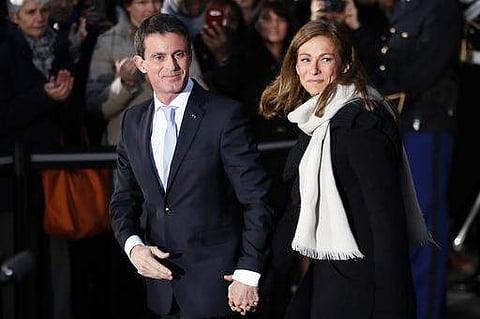 Outgoing Prime Minister Manuel Valls, left, and his wife Anne Gravoin leave after the hand over ceremony in Paris. AP