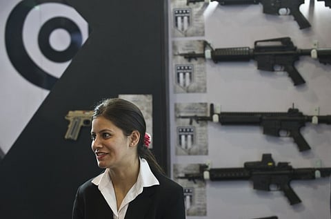 In this 2014 file photo, An exhibitor for US firearms manufacturer Colt looks on at the exhibition floor during the Defence Expo 2014 at Pragati Maidan in New Delhi. (AFP)