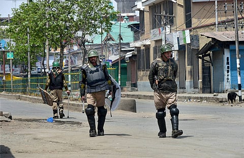 Security jawans guard a deserted street during the 4th consecutive day of strike and restrictions in Srinagar on Saturday. Authorities have imposed restrictions in the view of the strike called by separatists against the killing of five persons in Handwar