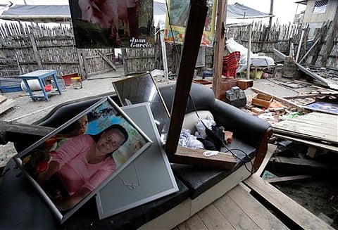 Framed family photos sit on a couch at a house damaged  by the 7.8-magnitude earthquake, in La Chorrera, Ecuador. |AP