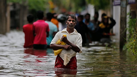 A Sri Lankan man walks through an alley that was flooded following heavy rains in the aftermath of Cyclone Ditwah in Colombo, Sri Lanka.