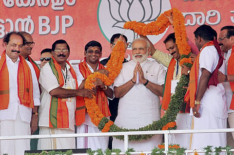 Prime Minister Narendra Modi being garlanded at an election campaign rally in Kasaragod. (PTI)