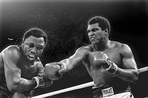 In this Oct. 1, 1975, file photo, spray flies from the head of challenger Joe Frazier as heavyweight champion Muhammad Ali connects with a right in the ninth round of their title fight in Manila, Philippines. (File|AP)