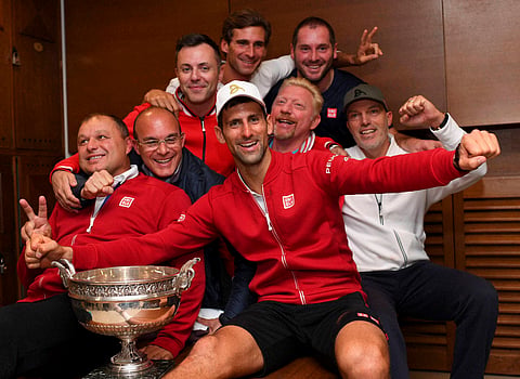 Novak Djokovic poses with his team in the dressing room after defeating Britain's Andy Murray in their final match of the French Open tennis tournament at the Roland Garros stadium Sunday June 5 2016 in Paris. | AP