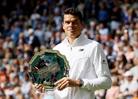 Milos Raonic of Canada holds his runner's up trophy after being beaten by Andy Murray of Britain in the men's singles final on day fourteen of the Wimbledon Tennis Championships in London. |AP