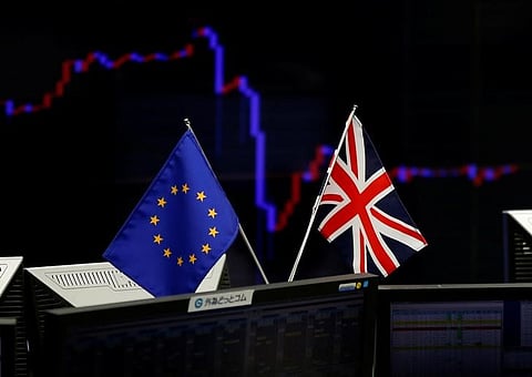 A British flag and an EU flag are seen in front of a monitor displaying a graph of the Japanese yen's exchange rate against the U.S. dollar at a foreign exchange trading company in Tokyo. (Reuters)