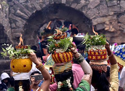 Women carrying Bonam ( a Pot fillerd with rice ) at Golconda fort during Bonalu Celebrations in Hyderabad.|  EPS/vinay Madapu