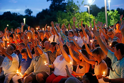 People holds up their hands in prayer during a candlelight vigil, for the Baton Rouge police officers killed, at the Healing Place Church in Baton Rouge, La. (AP)