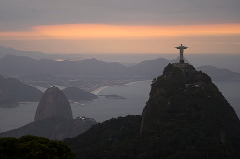 The Christ the Redeemer statue and Sugar Loaf mountain stand as the sun rises in Rio de Janeiro, Brazil. (AP)