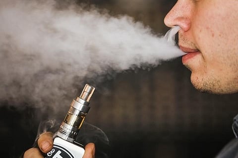 A man smokes an electronic cigarette vaporizer, also known as an e-cigarette. (File | Reuters)