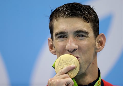 United States' Michael Phelps kisses his gold medal after the men's 4x100-meter freestyle final during the swimming competitions at the 2016 Summer Olympics. (AP)
