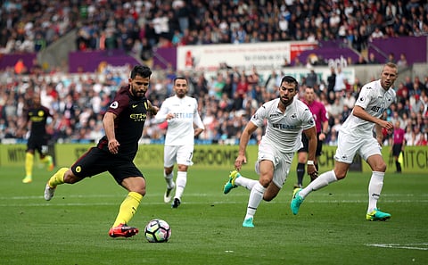 Manchester City's Sergio Aguero, left, scores his side's first goal during their English Premier League soccer match against Swansea at The Liberty Stadium, Swansea, England, Saturday Sept. 24, 2016. | AP