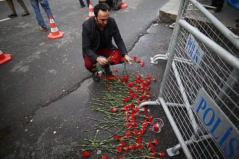 A man leaves flowers for the victims of the attack outside a a nightclub which was attacked by a gunman overnight, in Istanbul, on New Year's Day, Sunday, Jan. 1, 2017. | AP