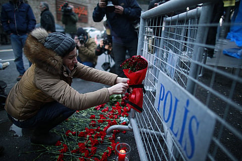 A young woman cries as she leaves flowers for the victims outside a nightclub which was attacked by a gunman overnight, in Istanbul, on New Year's Day, Sunday, Jan 1, 2017. | AP