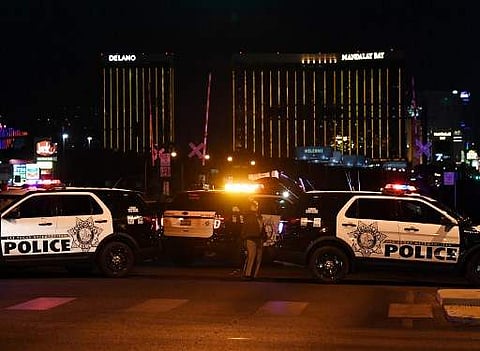 Police form a perimeter around the road leading to the Mandalay Hotel (background) after a gunman killed at least 58 people at a country music concert in Las Vegas, Nevada on October 2, 2017. (Photo | AFP)