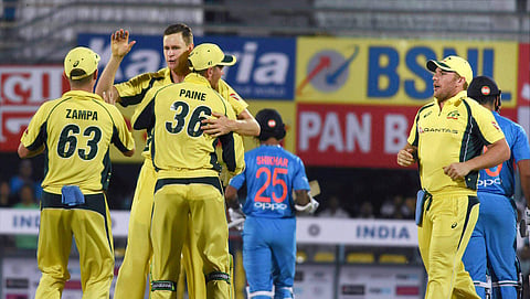 Australian bowler Jason Behrendorff with teammates celebrat after taking the wicket of Indian batsman Rohit Sharma during their second T20 cricket match in Guwahati on Tuesday. | PTI