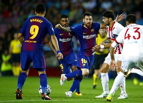 Barcelona's Lionel Messi, center, plays with teammate Luis Suarez, left, during the group D Champions League soccer match against  Olympiakos. | AP