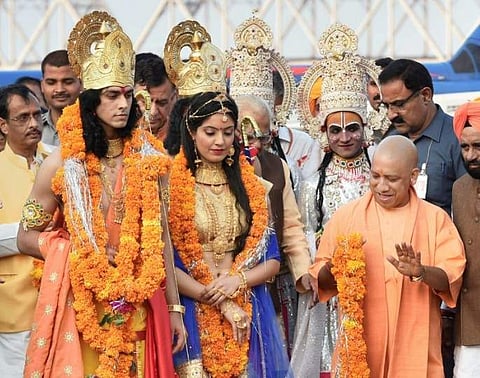 Caption: Ayodhya Uttar Pradesh Chief Minister Yogi Adityanath welcoming the artistes dressed up as Lord Rama and Sita during Deepotsav celebrations in Ayodhya on Wednesday. | AP