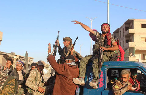 In this picture taken on Monday Oct. 16, 2017 and provided by The Syrian Democratic Forces (SDF), a U.S.-backed Syrian Kurdish forces outlet that is consistent with independent AP reporting, shows Syrian Democratic Forces (SDF) fighters, sit on their pick