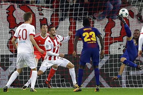 Barcelona's Luis Suarez, right, tries to score with a bicycle kick as Olympiakos goalkeeper Silvio Proto, second left, watches the ball during the Champions League group D soccer match between Olympiakos and Barcelona at Georgios Karaiskakis stadium. | AP