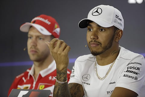 Mercedes driver Lewis Hamilton of Britain, right, sits next to Ferrari driver Sebastian Vettel of Germany during a news conference at the Yas Marina racetrack in Abu Dhabi, United Arab Emirates. | AP