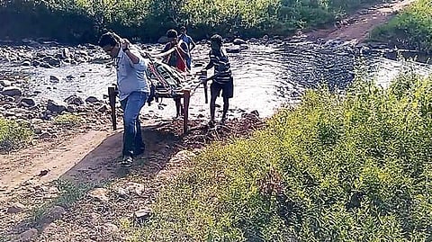 Dr Omkar Hota and others taking the woman on a cot to hospital | press