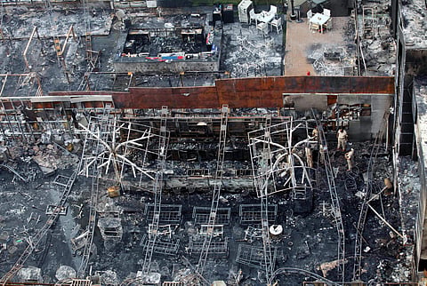 Policemen inspect the building in which a fire broke out in Mumbai on Friday. | PTI