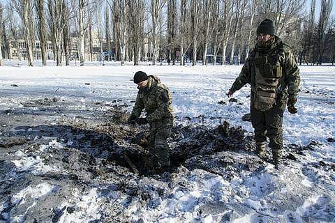 A Ukrainian soldier inspects a crater left by an explosion in Avdiivka, Ukraine, Tuesday, Jan. 31, 2017. Fighting between government troops and Russia-backed separatist rebels in eastern Ukraine escalated on Tuesday, killing at least eight people late Mon