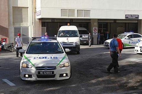 Police officers wait at the forensic department entrance at a hospital in Putrajaya, Malaysia on Wednesday, Feb. 15, 2017.  AP