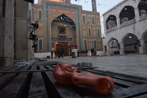 A doll lies on the ground of the 13th century Sufi shrine of Lal Shahbaz Qalandar a day after a bomb attack in the town of Sehwan in Sindh province of Pakistan, some 200 km northeast of Karachi on February 17, 2017. Nearly 100 people were killed when an Islamic State suicide bomber blew himself up inside the crowded shrine of a revered Sufi holy man Lal Shahbaz Qalandar. | AFP