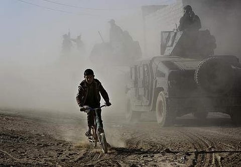 File photo of an Iraqi boy  on his bicycle as he follows the special forces in Mosul.(File Photo |AP)