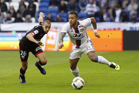 Lyon's Memphis Depay, right, challenges for the ball with Dijon's Fouad Chafik, left, during their French League One soccer match in Decines, near Lyon, central France, Sunday, Feb. 19, 2017. | AP