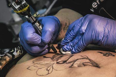 Tattoo artist Yevgeniya Zakhar works on a tattoo for a victim of domestic violence, in Ufa, Russia. (File | AP)