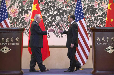 U.S. Secretary of State Rex Tillerson, left, and Chinese Foreign Minister Wang Yi reach to shake hands at the end of a joint press conference following their meeting at the Diaoyutai State Guesthouse in Beijing, China, Saturday, March 18, 2017. | AP